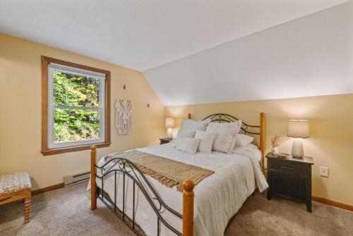 a bedroom with a large bed and a window at Dog-Friendly Retreat, Fire Pit, Lakes Region in Gilmanton