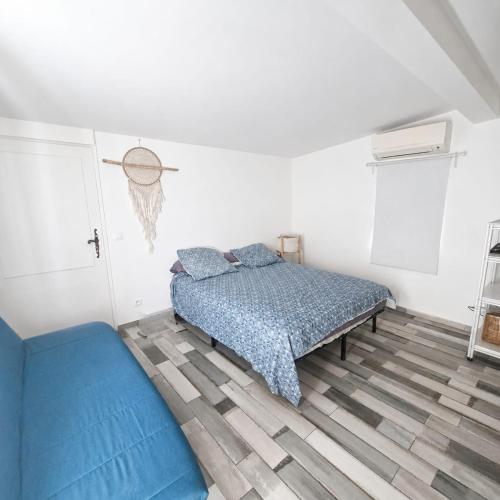 a bedroom with a bed and a blue comforter at Pollart in Les Arcs sur Argens