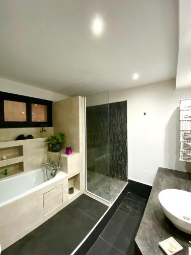 a bathroom with a tub and a sink at Sunny Suites Madagascar in Antananarivo