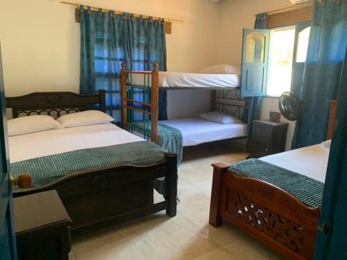 a room with three bunk beds in a house at Casa de Playa Madeleyne in Taganga