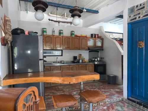 a kitchen with a wooden table and a refrigerator at Casa de Playa Madeleyne in Taganga