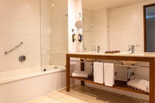 a bathroom with a sink and a tub and a shower at Hotel Patagonico in Puerto Varas