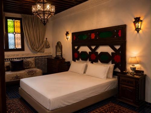 a bedroom with a bed and a stained glass window at Dar Laabi - Riad Aya in Fez