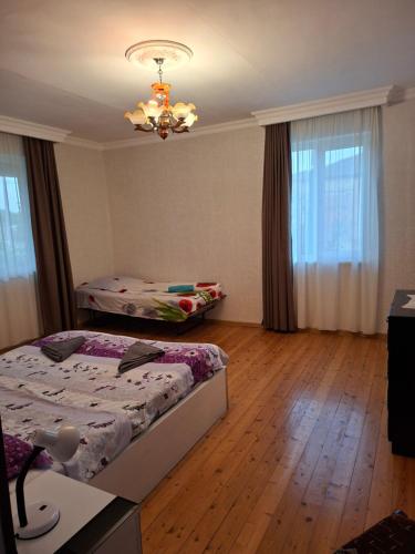 a bedroom with two beds and a chandelier at Colourful Udabno in Udabno