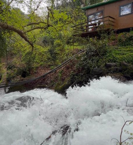 a house on a hill next to a river at Selale Cennet Evleri in Kemer