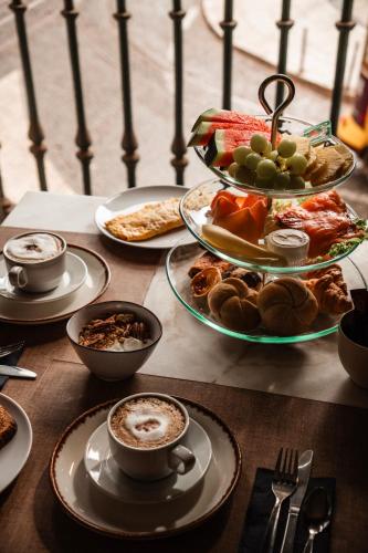 a table with plates of food and cups of coffee at Le Consulat in Lisbon