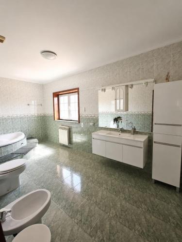 a bathroom with two toilets and a sink and mirrors at Casa Corujeira in Santa