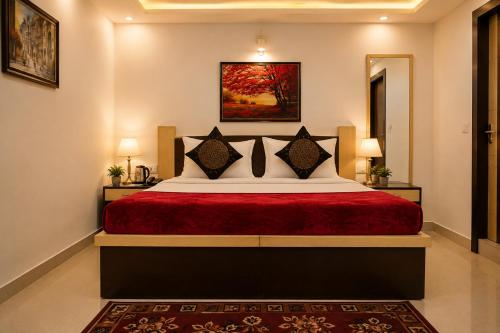 a bedroom with a bed with a red bedspread at Hotel Bed & Room in Agra