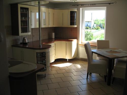 a kitchen with a table and chairs and a window at POD DĘBEM in Cerkiewnik