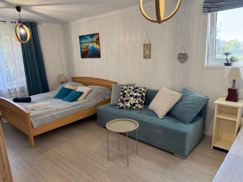 a bedroom with a bed and a blue couch at Dom nad Wigrami in Suwałki