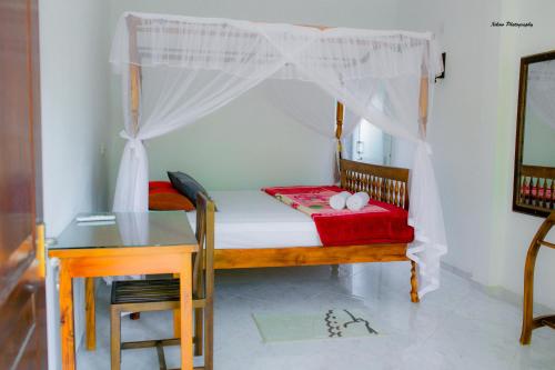 a bedroom with a bed and a table and a desk at The Fort House - Matara in Matara