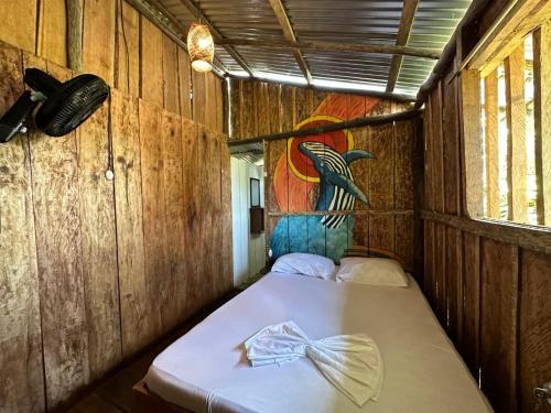 a bed in a room with a painting on the wall at Waikiki Pacific Hostel in Buenaventura