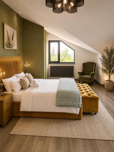 a bedroom with a large bed and a chair at Maison Royale in Otopeni
