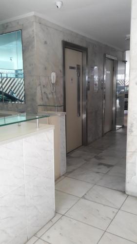 a lobby with two elevators in a building with a tile floor at Marisia in Guarujá