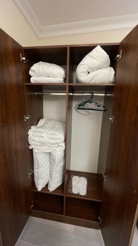 a closet with white towels and folded towels at Mahalla Old City Samarkand in Samarkand