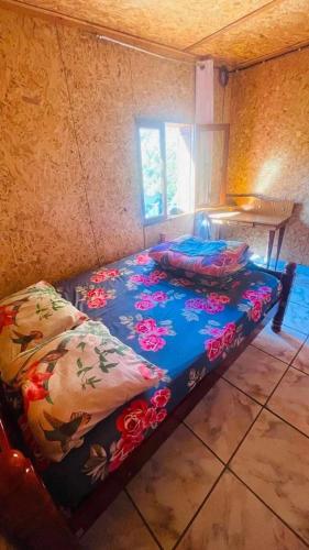 a bedroom with a bed with flowers on it at Gite Chez Théo in Saint-Paul