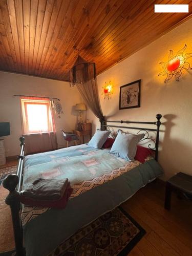 a bedroom with a bed with a wooden ceiling at Maison L'étalonblanc in Tupin-et-Semons