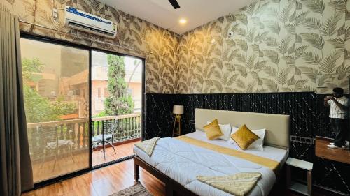 a bedroom with a bed and a large window at Elite Boutique Stays in Ujjain