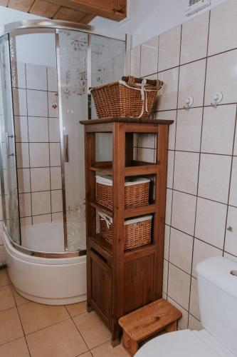 a bathroom with a shower and a cabinet with baskets on it at Dom wakacyjny Podlas in Żywiec