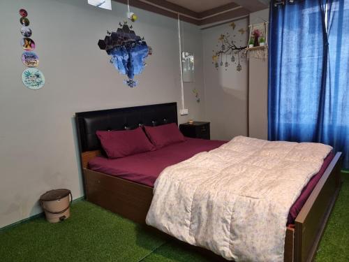 a bedroom with a large bed with purple sheets at North Queen Homestay in Darjeeling