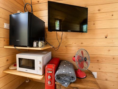 a kitchen with a microwave and a tv and a fan at La Tiny de Lili in Draveil