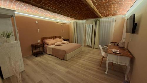 a bedroom with a bed and a desk and a table at San Lorenzo Suite in Tigliole