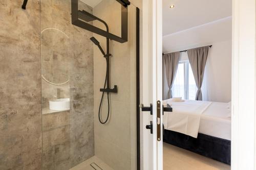 a shower with a glass door in a bedroom at Stone house Mia in Čara