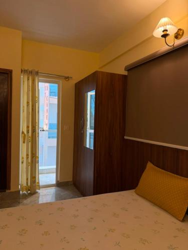 a bedroom with a bed with a lamp and a window at Namma HomeSlice, Balcony Rooms in Brookefield in Bangalore