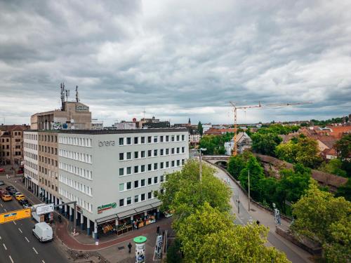 a large white building on a city street with traffic at Brera Nürnberg in Nuremberg