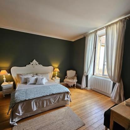 a bedroom with a bed and a green wall at La Villa Regula in La Réole