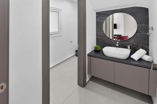 a bathroom with a sink and a mirror at Sun & Moon Luxury - Eclipse Villa in Ayia Napa