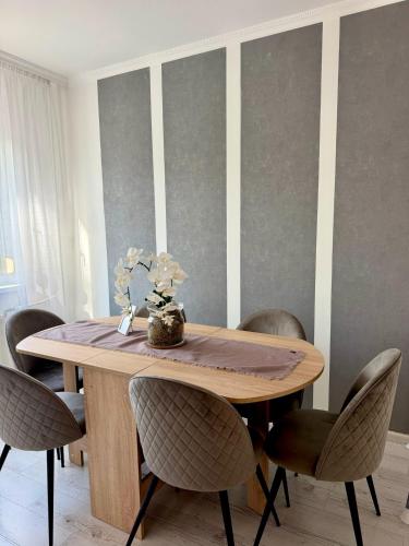 a dining room with a wooden table and chairs at 2-6 Apartman Szeged in Szeged