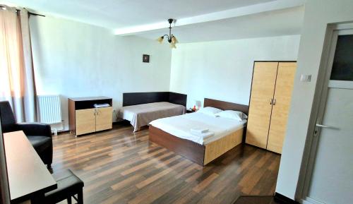 a bedroom with a bed and a dresser at Titulescu Apartments in Bucharest