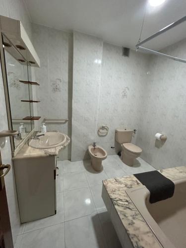 a bathroom with a sink and a toilet and a tub at Apartamento céntrico Prado Blanco in Finisterre