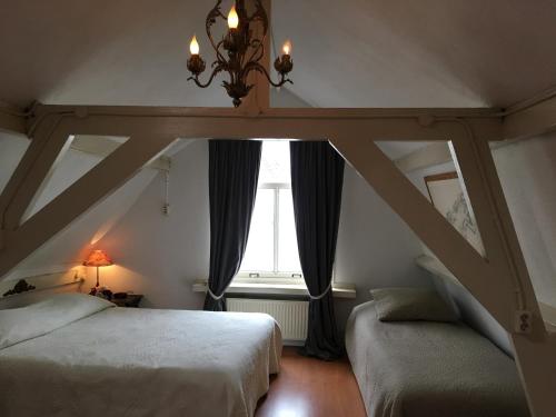 a bedroom with two beds and a window at La Perle Apartment in Utrecht