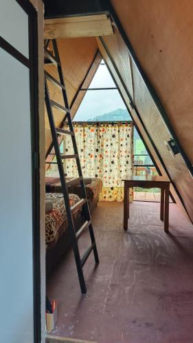 a ladder in a room with a bed and a table at Cabañas Ticomulco in Zacatlán