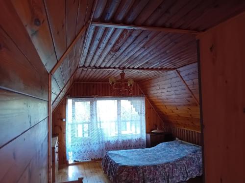 an attic bedroom with a bed and a window at U Peterki in Woryty