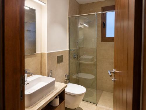 a bathroom with a sink and a toilet and a shower at Valley Farmhouse By Bait Zain in As Sīfah