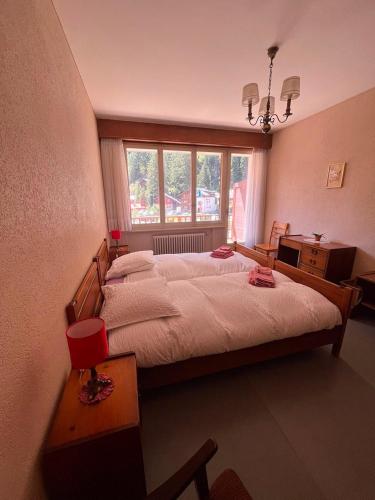 a bedroom with a large bed and a window at Hôtel Grand-Combin in Fionnay