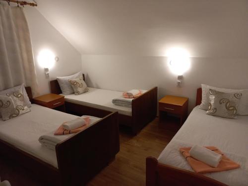 a room with three beds with lights on at Apartmani Sobe Šljivančanin in Žabljak