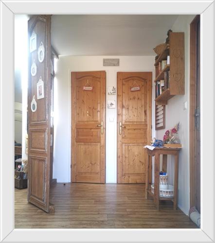 a hallway with two wooden doors in a room at Chambre d'hôtes de Marie in Chémery