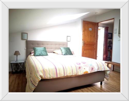 a bedroom with a large bed with green pillows at Chambre d'hôtes de Marie in Chémery