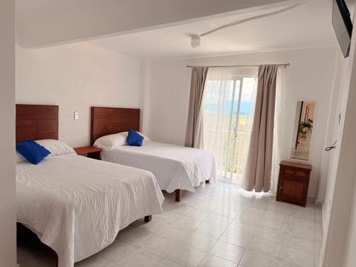 a hotel room with two beds and a window at Hotel Fernando´s in Tlalpujahua de Rayón