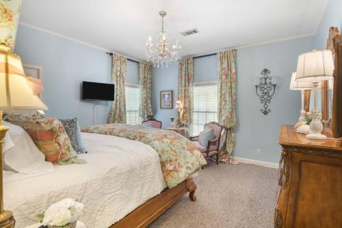 a bedroom with a large bed and a chandelier at King bed! Gameroom! Super cozy-The Treasured Mist! in Fort Smith