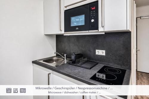a kitchen with a sink and a microwave at MIILOX Apartments Dresden in Dresden