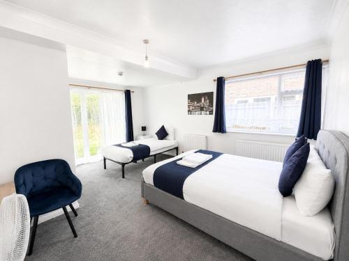 a bedroom with a king sized bed and a chair at High Trees Guest House Gatwick in Horley