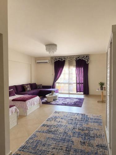a living room with a purple couch and a rug at Marina Valley مارينا فالي in El Alamein