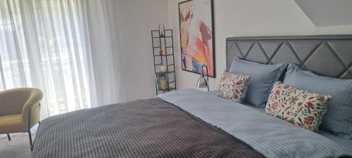 a bedroom with a large bed with blue pillows at Apartman Romansa in Fojnica