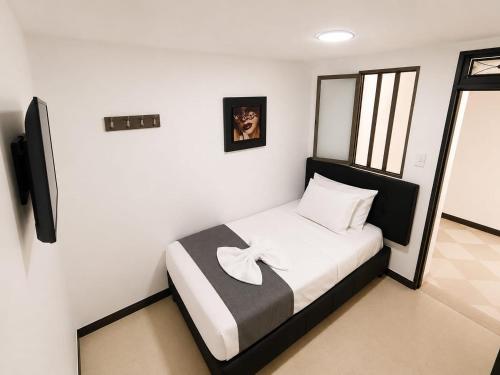 a bedroom with a bed with a bow on it at Hotel Nexo in Medellín