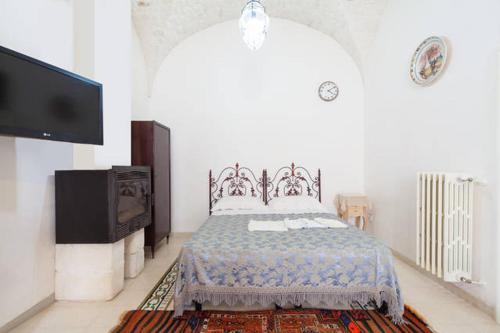 a bedroom with a bed and a flat screen tv at Casa Meravigliosa in Ostuni